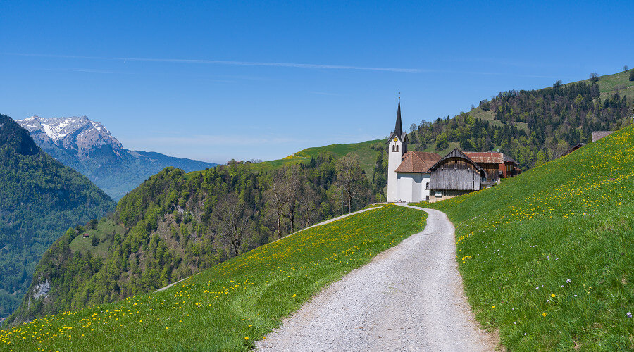 Weg zu einer Kirche in den Bergen im Sommer