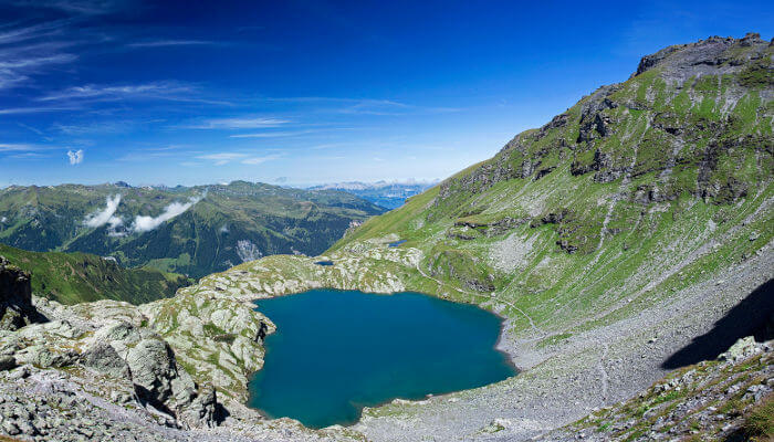 Bergsee in der Sonne zwischen Bergen
