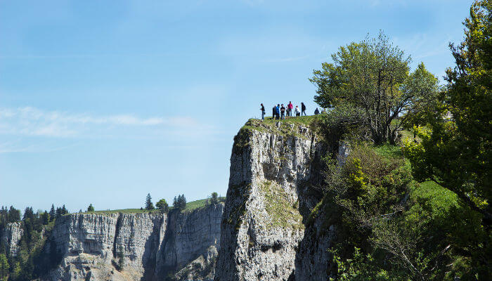 Menschen nah am Abgrund der steilen Felswände des Creux du Van