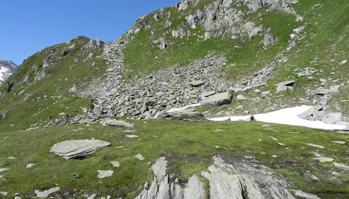 Steine auf Wiese an einem Berghang