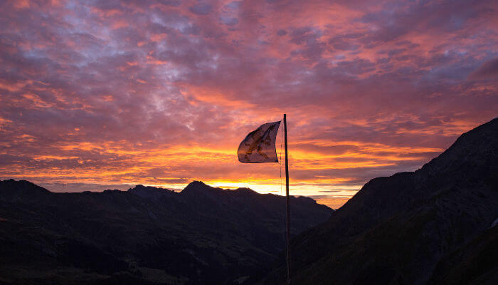 Sardonahütte mit Fahne im Morgenrot