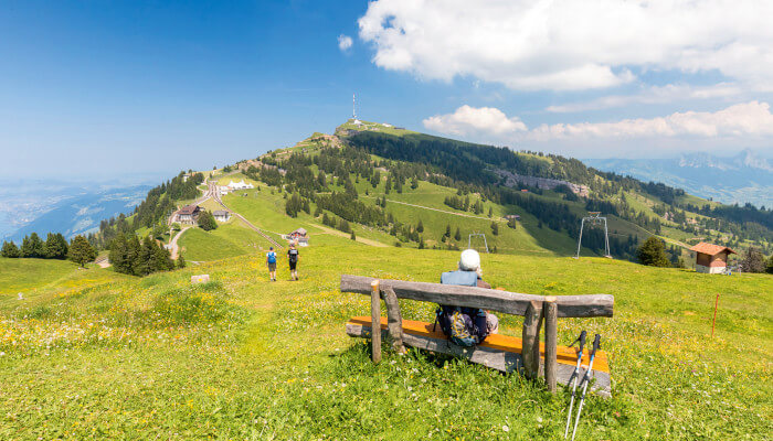 Wanderin auf Holzbank auf dem Rigi Rotstock