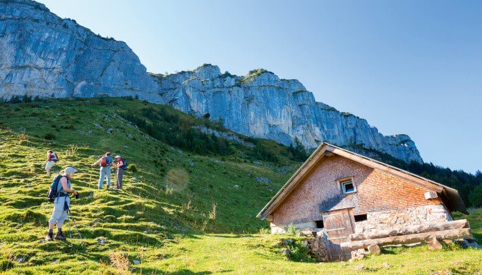 Berghütten und Wanderer bei sonnigem Wetter