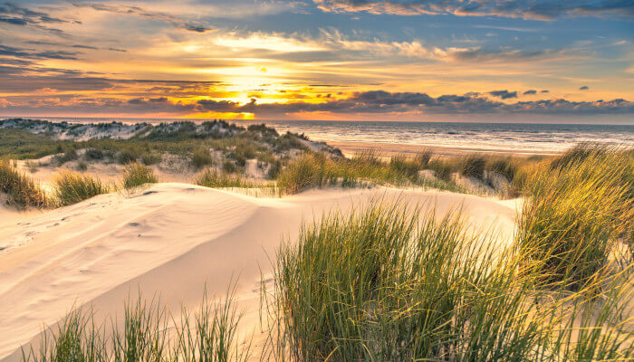 Sandstrand vor Meer an einem sonnigen Abend