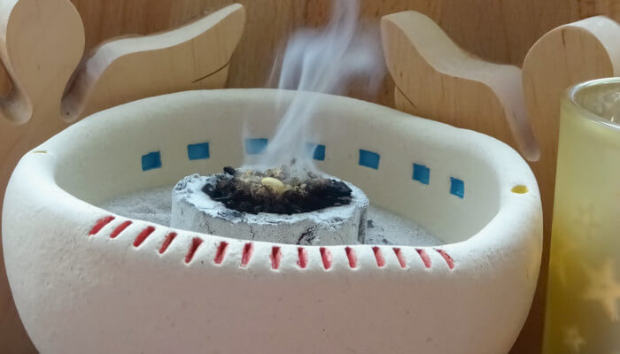 weisse Räucherschale mit rauchender Kräutermischung