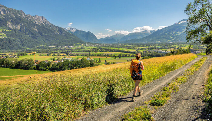 Wanderweg mit Wanderin durch Herbstfelder