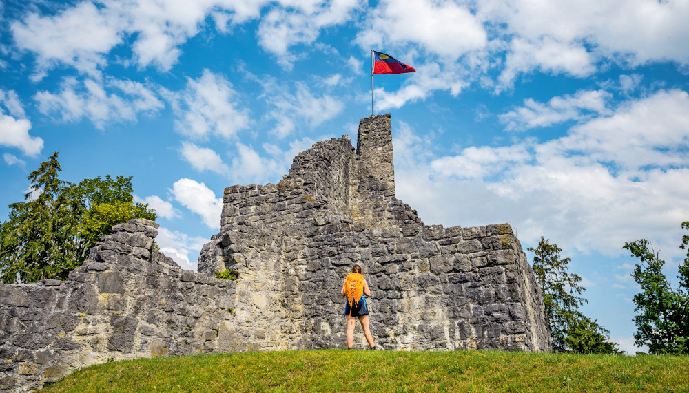 Wanderer vor einer Burgruine im Sommer